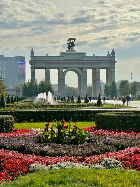 A monumental arch beyond flowerbeds, Russia