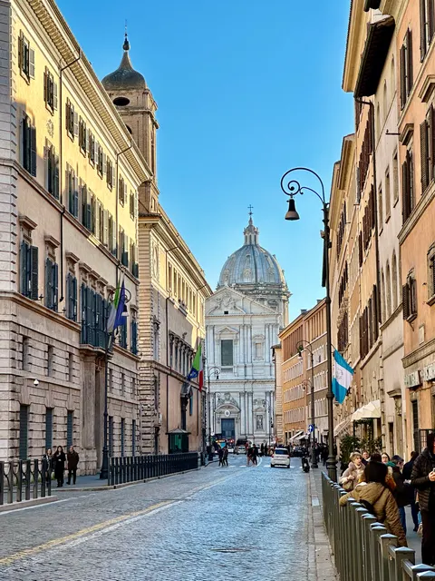 A quiet Roman street leading to a dome, Italy