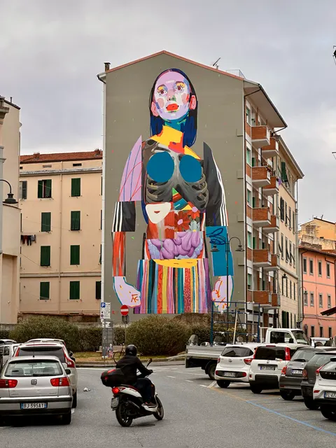 A colorful mural above a narrow street, Italy