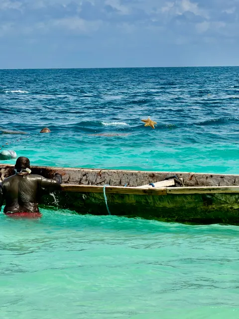 A wooden boat on turquoise water, Tanzania
