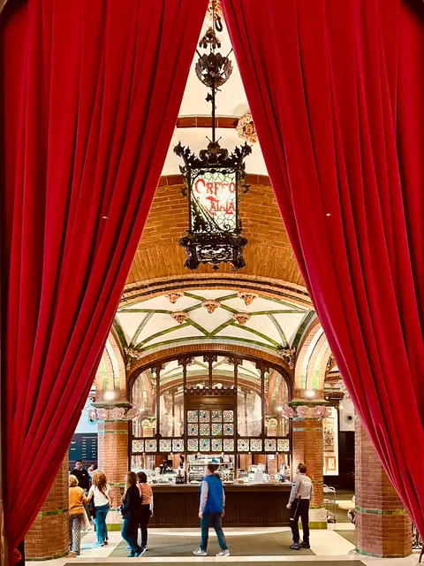 An ornate concert hall framed by red curtains, Spain