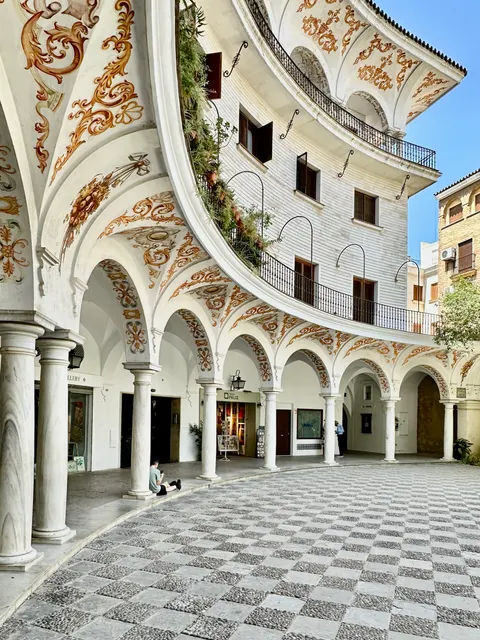 An arcaded courtyard with patterned tiles, Spain