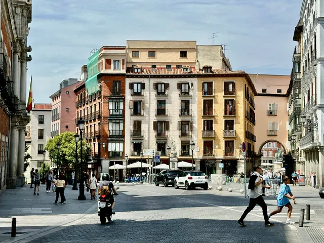 A busy city street beneath pale skies, Spain
