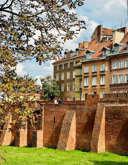 Brick city walls beneath autumn trees, Poland