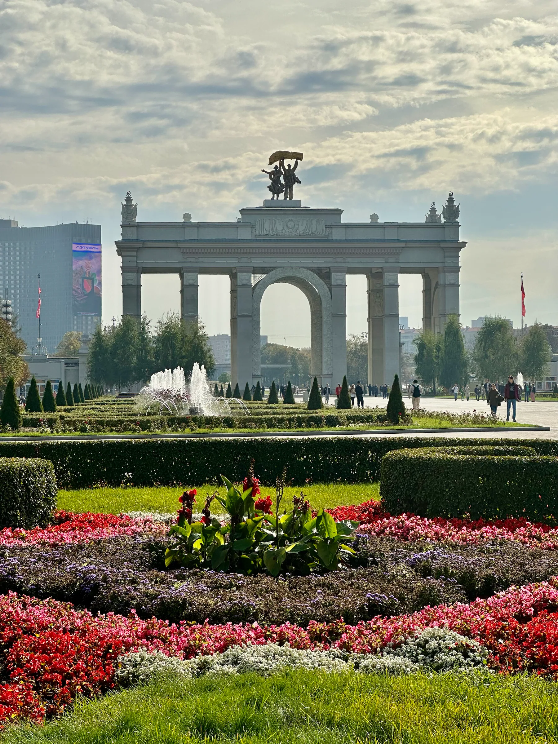 A monumental arch beyond flowerbeds, Russia