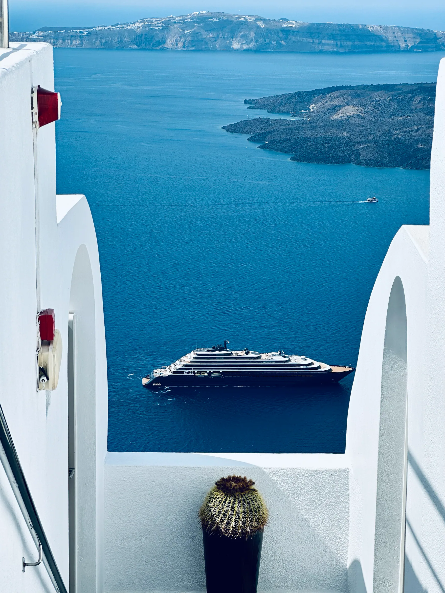 A cruise ship framed by whitewashed walls, Greece