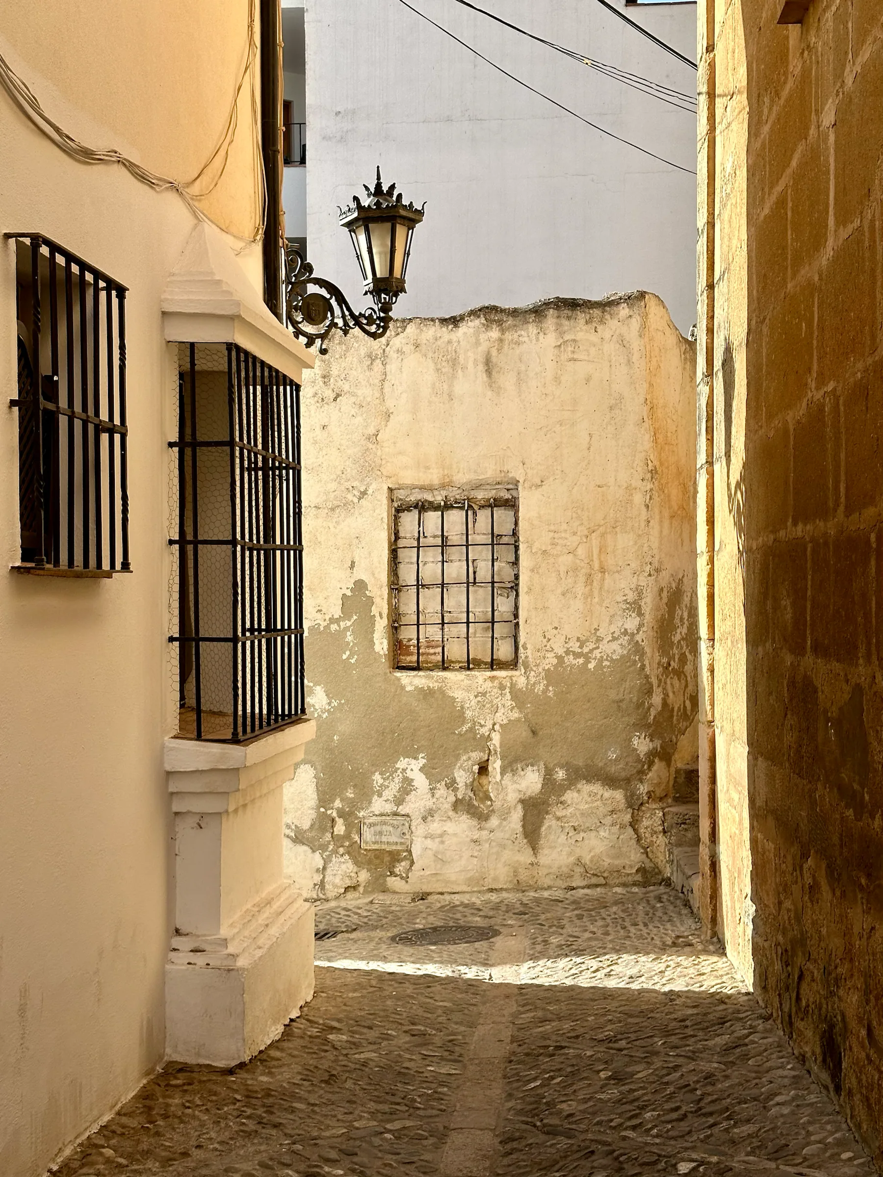 A quiet passage beside whitewashed walls, Spain