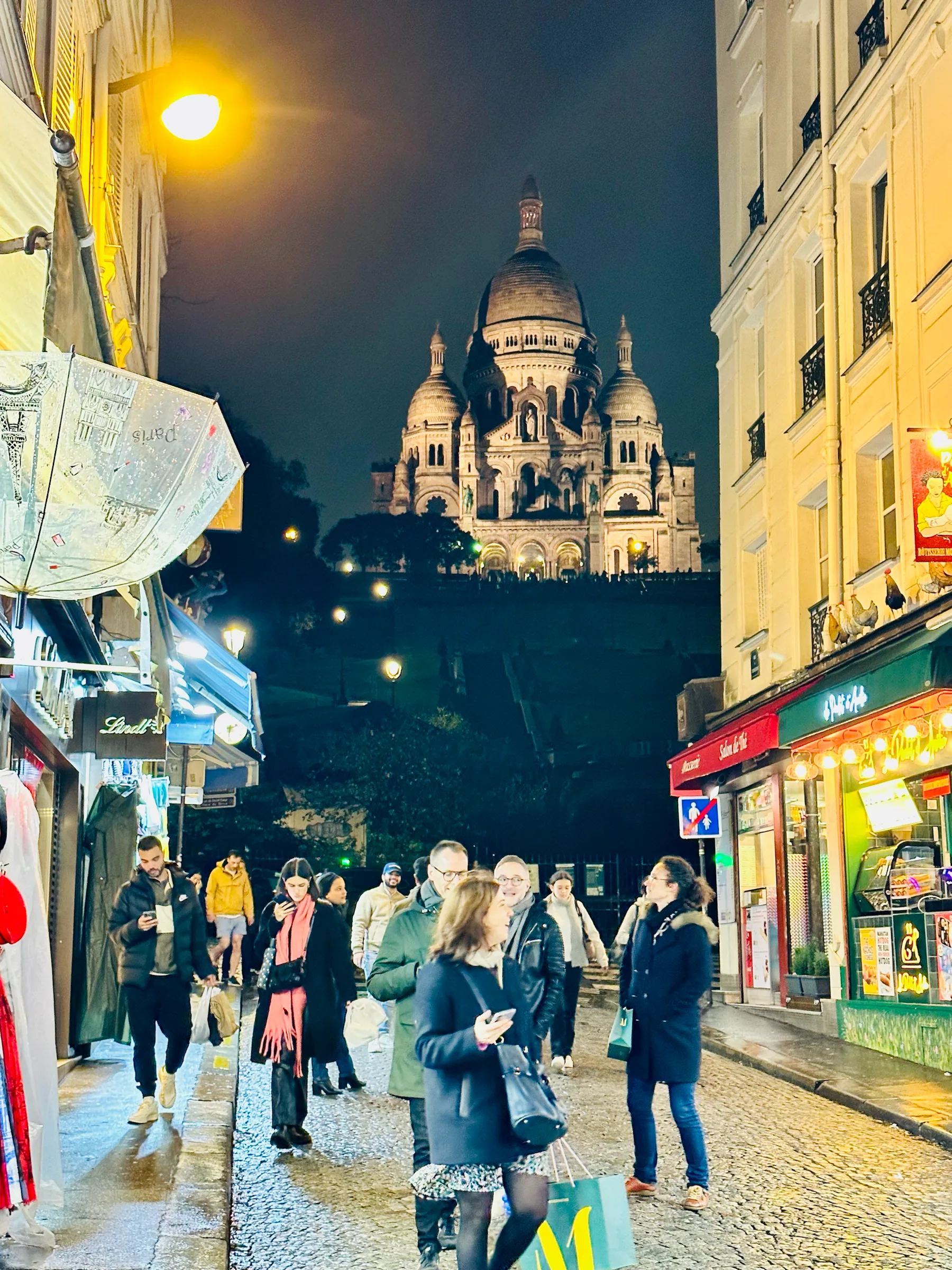 Sacré-Cœur above a lively evening street, France